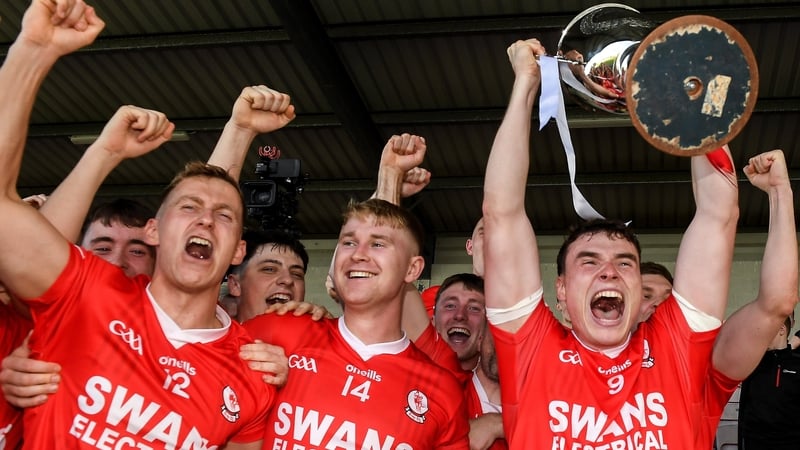 Éire Óg captain Jordan Morrissey lifts the cup