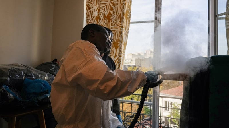 A pest control worker sprays insect killer solution in an apartment containing bed bugs in Paris