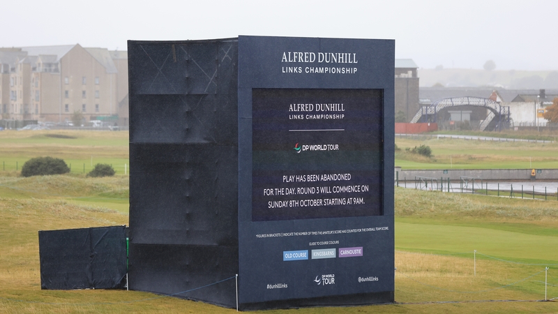 A display on course reads "play has been abandoned for the day, round 3 will commence on Sunday 8th October starting at 9am"