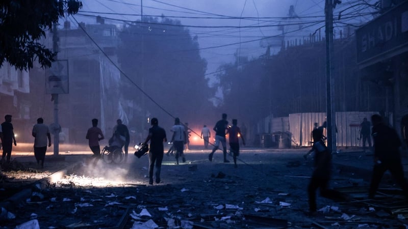 People run along a debris-strewn street following Israeli air strikes in Gaza City