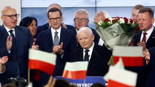 Jaroslaw Kaczynski (centre) reacts with supporters at the party's headquarters in Warsaw last night