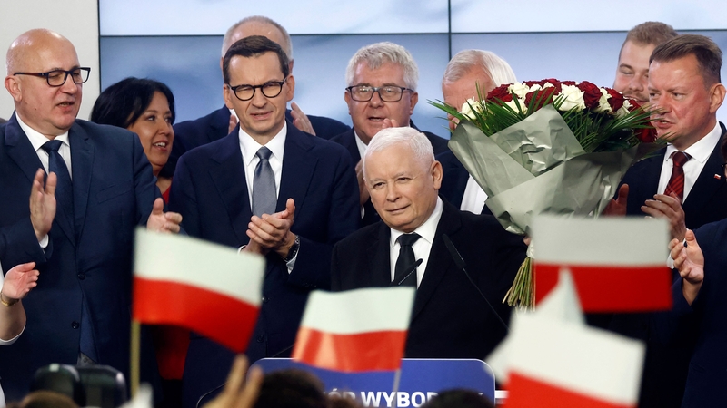 Jaroslaw Kaczynski (centre) reacts with supporters at the party's headquarters in Warsaw last night