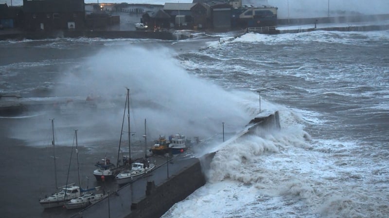 Waves crash over Stonehaven harbour on the east coast of Scotland as wind and rain from Storm Babet sweeps in