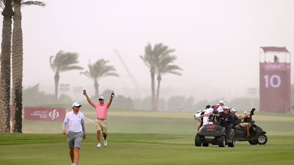 Players and caddies are taken back to the clubhouse as play is suspended due to adverse weather