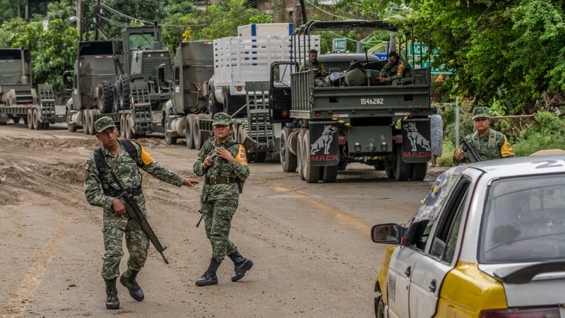 Mexican Army soldiers stranded as they wait for the engineer corps to fix a fallen bridge in the aftermath of Hurricane Otis