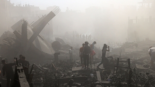 Palestinians search for survivors and the bodies of victims through the rubble of buildings destroyed during Israeli bombardment in Khan Yunis