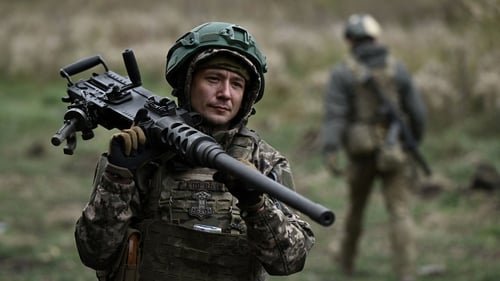 A Ukrainian serviceman of the 3rd assault brigade carries a Browning M2 machinegun during a tactical training in an undisclosed location in the Donetsk region
