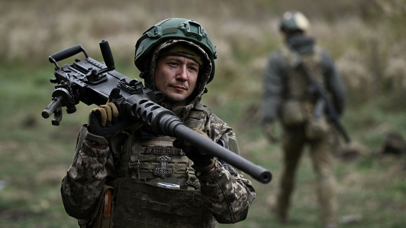 A Ukrainian serviceman of the 3rd assault brigade carries a Browning M2 machinegun during a tactical training in an undisclosed location in the Donetsk region