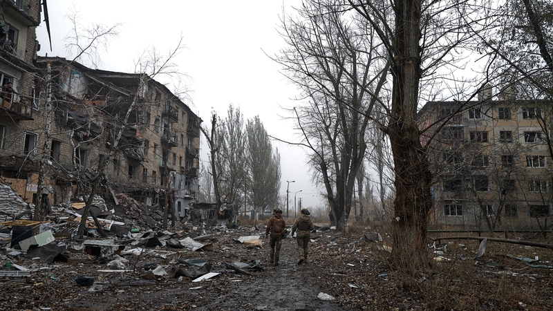 Two Ukrainian soldiers walk through the destroyed town of Avdiivka on October 26, 2023