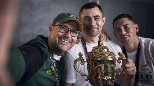Jacques Nienaber (l) and Felix Jones (c) celebrate with the Webb Ellis