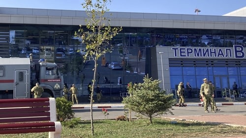 Law enforcement officers patrol an area outside the airport in Makhachkala