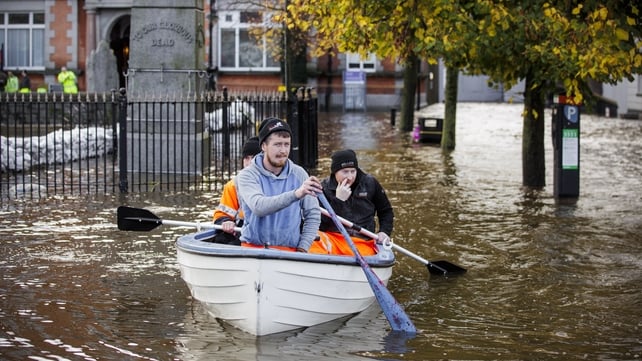 People canoe down a flooded Bank Parade