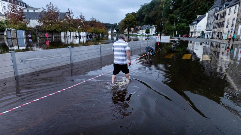 A local resident walks through a flooded street after the area was affected by an heavy storm in Quimperle, western France