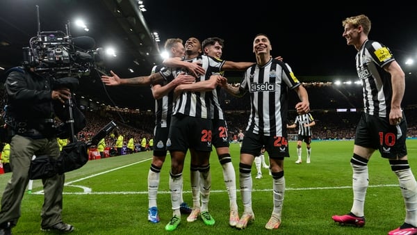 Joe Willock is embraced by his Newcastle team-mates after scoring the third goal at Old Trafford