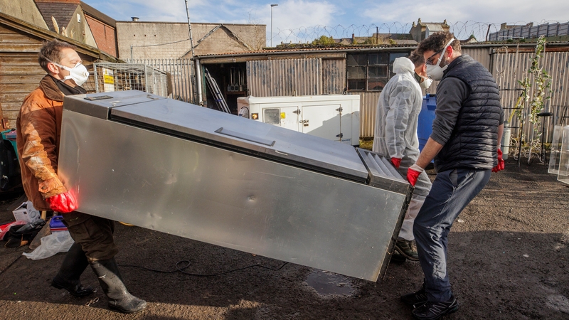 Darren Kearney, right, of Oakley Fayre cafe and deli moves a fridge during the clean up of his business in Downpatrick, Co Down