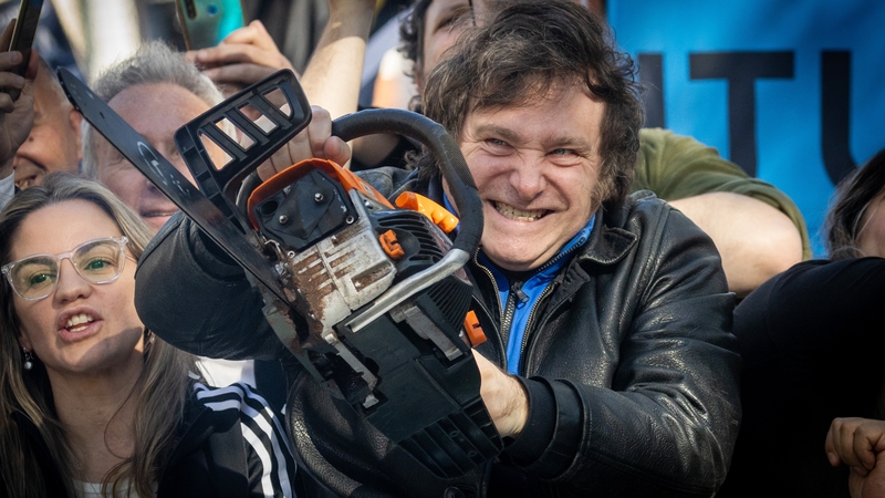 Javier Milei lifts a chainsaw during a rally in September