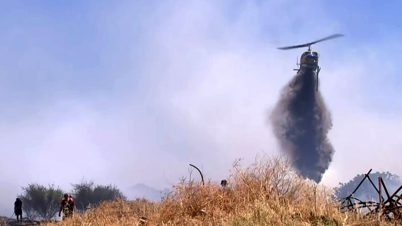 Helicopter dumping water on a bushfire in the town of Kwinana, south of Perth, Australia