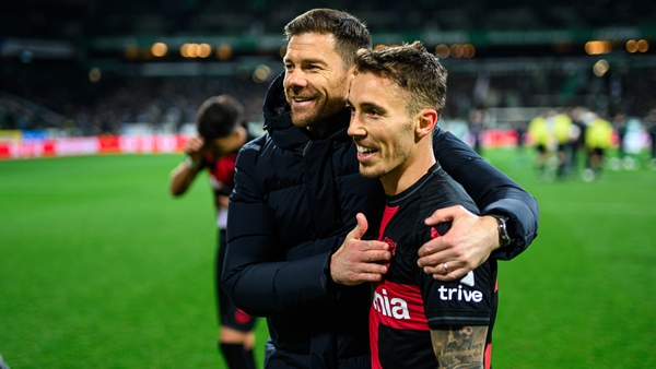 Bayer Leverkusen manager Xabi Alonso embraces goalscorer Jeremie Frimpong