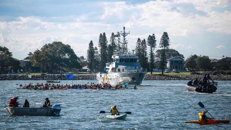 Police force the protestors to leave the water as they continue to block access to the coal port