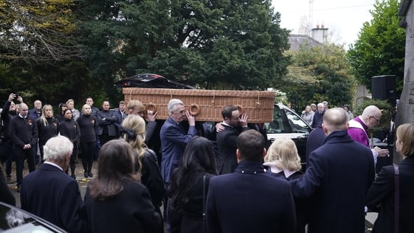 A wicker coffin carrying Ben Dunne's remains is carried into St Mochta's Church in Clonsilla