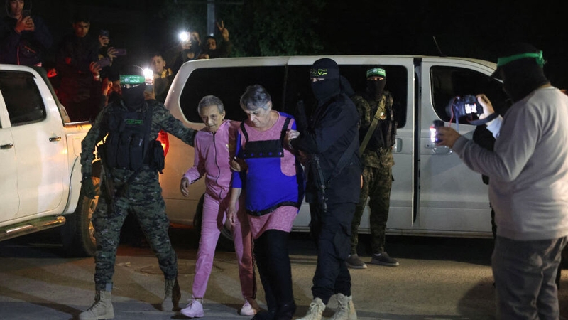 Hamas and Islamic Jihad fighters accompany newly-released hostages before handing them over to the Red Cross