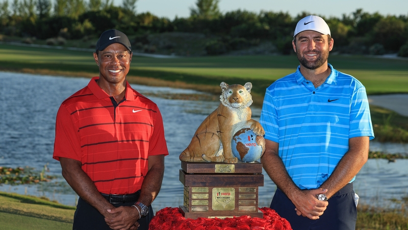 Scottie Scheffler is presented with the Hero World Challenge Trophy by tournament host Tiger Woods