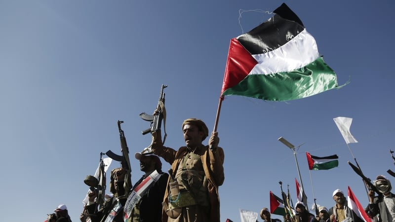 Houthi rebels holding up guns and a Palestinian flag at a parade in Yemen recently (file image)