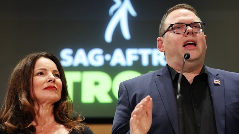 SAG-AFTRA President Fran Drescher and SAG-AFTRA National Executive Director Duncan Crabtree-Ireland speaking at a press conference discussing their strike-ending deal with the Hollywood studios