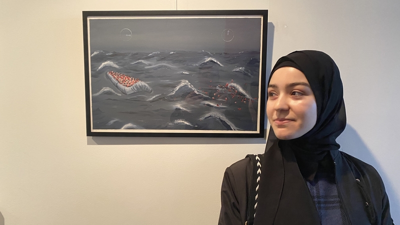 Heba Haj Habo beside one of her artworks