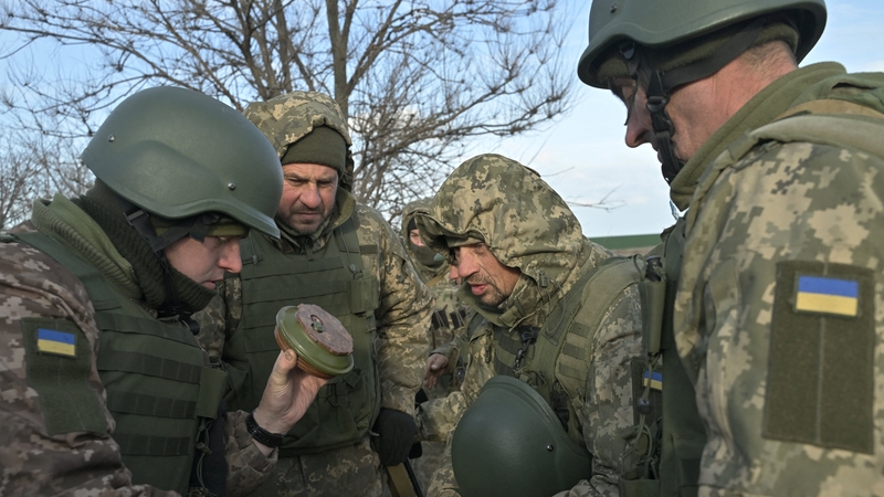 Ukrainian servicemen examine an anti-tank mine detonator during an exercise in the Donetsk region