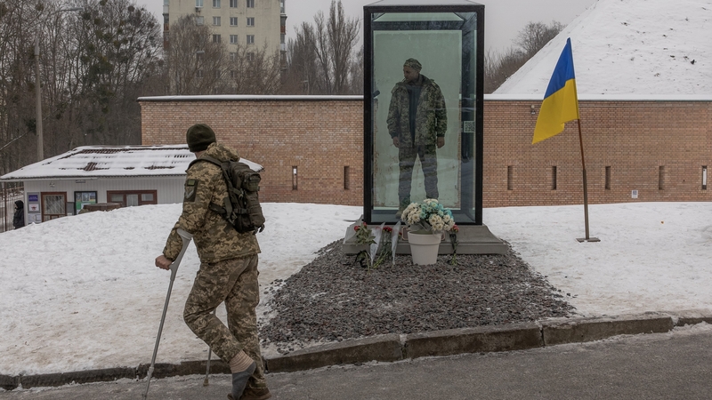 A Ukrainian solider looks at a memorial to killed Ukrainian soldier Oleksandr Matsievsky in Kyiv