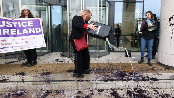 Climate protesters pouring a black gel on the ground at the JP Morgan building in Dublin