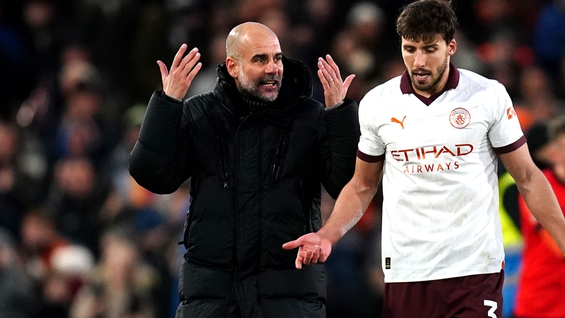 Manchester City manager Pep Guardiola (L) speaks to Ruben Dias after the final whistle