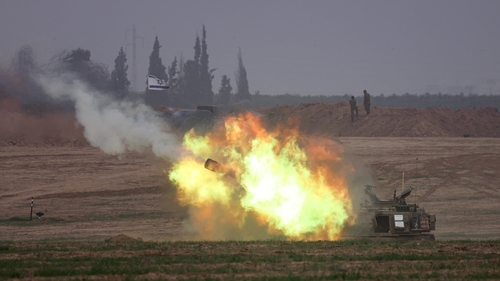 An Israeli army self-propelled artillery howitzer fires rounds from a position near the border with Gaza