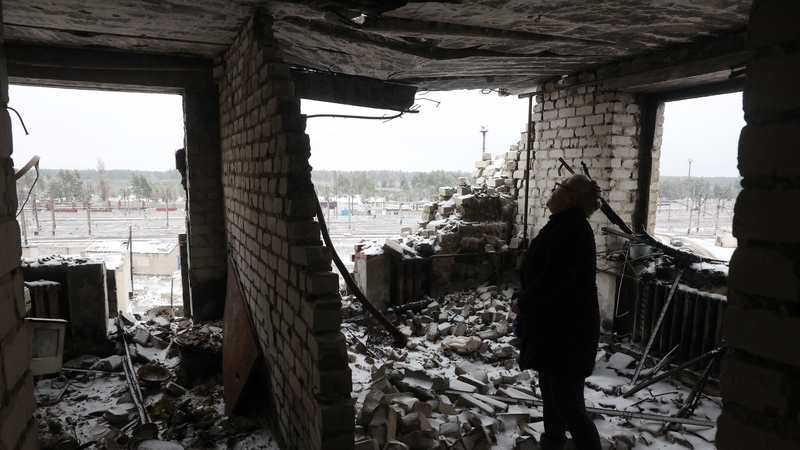A woman stands in her apartment that was destroyed during shelling in Lyman, Donetsk region over the weekend