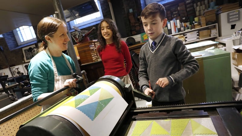 Mary Plunkett and school children Ana Rubia Marques Da Hora and Andrew McNally printing a limited artwork to mark the exhibition