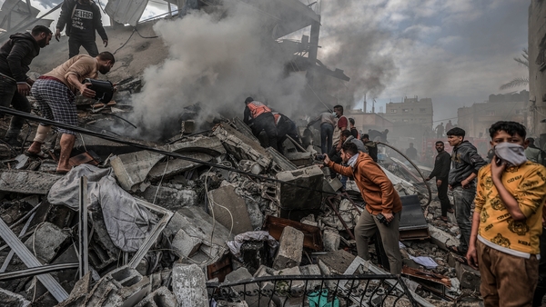 Civil defense teams and Palestinians conduct search and rescue operations among the rubble of buildings destroyed by Israeli attacks in Rafah