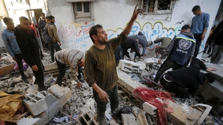 Palestinian civilians search the rubble of destroyed buildings after an Israeli airstrike on Deir al-Balah