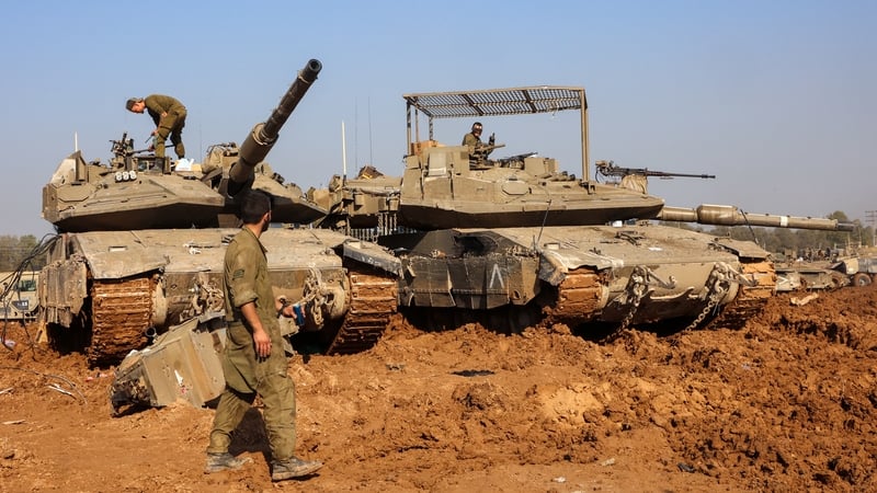 Israeli soldiers carry out maintenance on tanks in southern Israel near the border with Gaza today