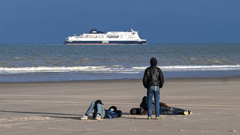 Three men are seen on a beach in Sangatte, northern France, after a failed attempt to cross the English Channel