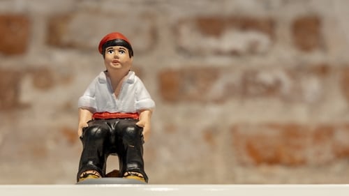 The traditional clay figure depicts a peasant or shepherd wearing black trousers, a white shirt and the classic red Catalan cap called the barretina