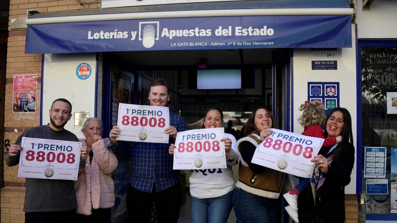 Shop staff celebrate after selling winning tickets for Spain's Christmas lottery