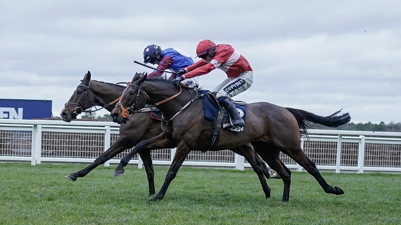 Jonathan Burke riding Crambo (red) clears the last to win The Howden Long Walk Hurdle from Tom Bellamy and Paisley Park (blue)