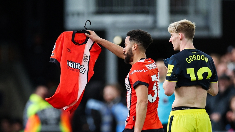 Andros Townsend holds up Tom Lockyer's number four jersey after scoring against Newcastle