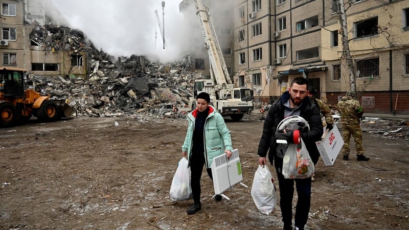 Residents carry their belongings from a residential building destroyed after a missile strike, in Dnipro, Ukraine, on 15 January.