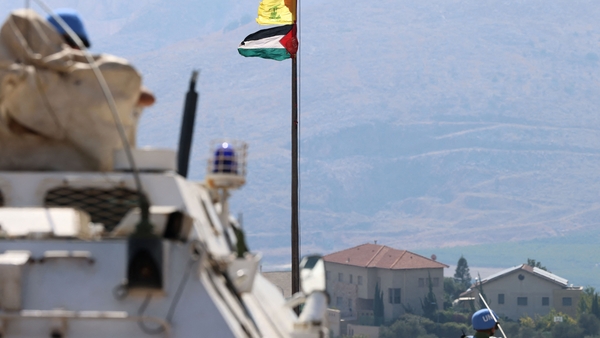 The Palestinian and Hezbollah flags wave in the wind as peacekeepers from UNIFIL patrol the border area between Lebanon and Israel