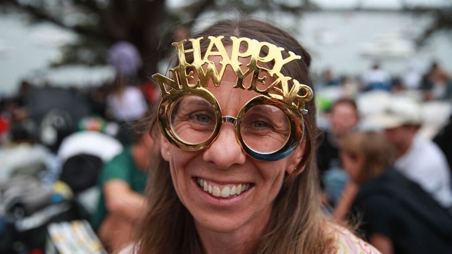 A woman wears a 'Happy New Year' headpiece at Mrs Macquarie's Chair in Sydney
