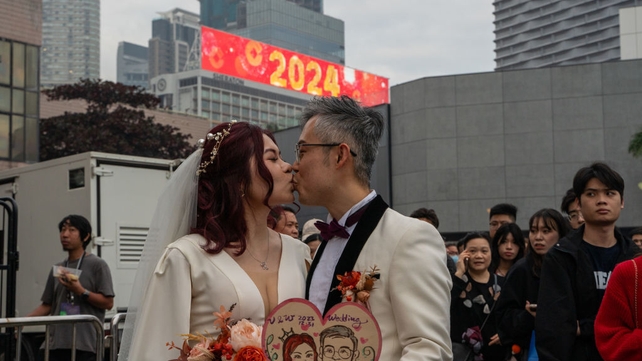 A newlywed couple kiss in Hong Kong
