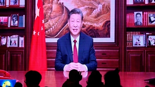 People watch China's President Xi Jinping deliver his New Year's speech in Beijing