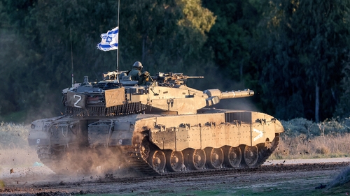 An Israeli army battle tank moves along the border with Gaza